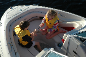 Boy and girl wearing children's life jackets sitting the bow.