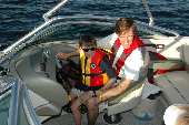 Man wearing inflatable life jacket with boy wearing children's life jacket